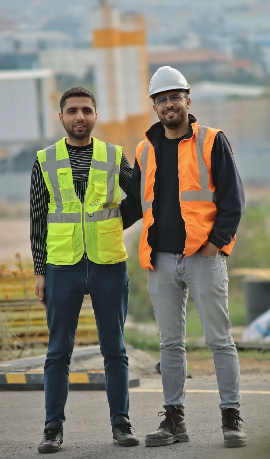 Two people wearing high-visibility vests outdoors