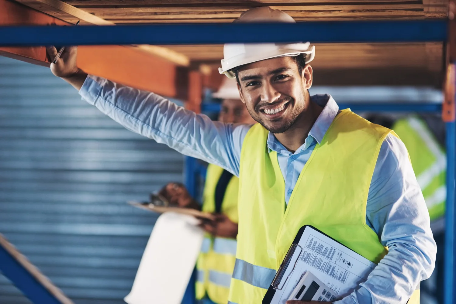 Person in a hard hat and safety vest at a workplace